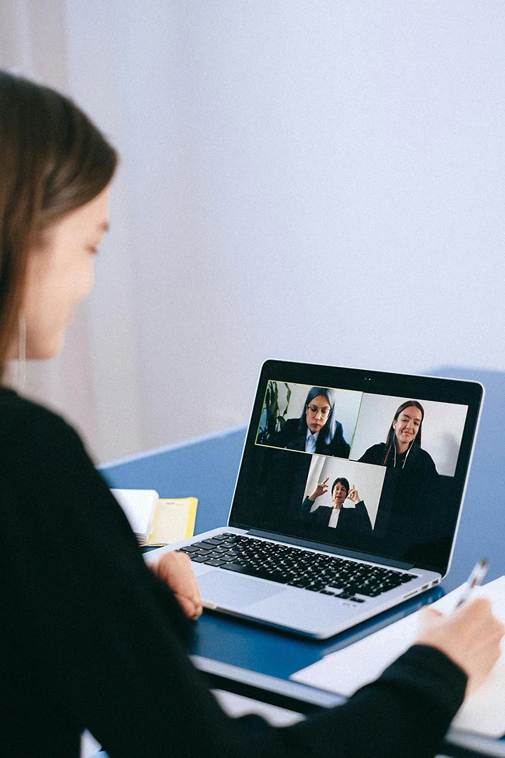 Woman in an online meeting with two other people, all with their cameras turned on