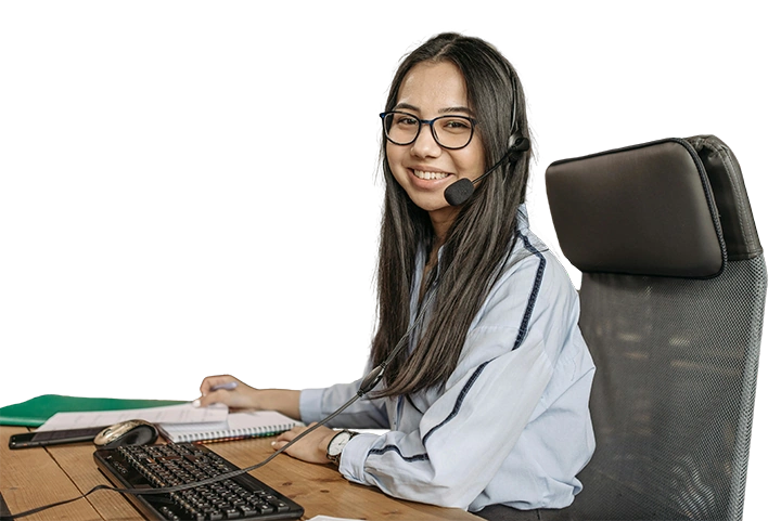 Smiling woman wearing a headset, sitting in front of a keyboard, facing the camera